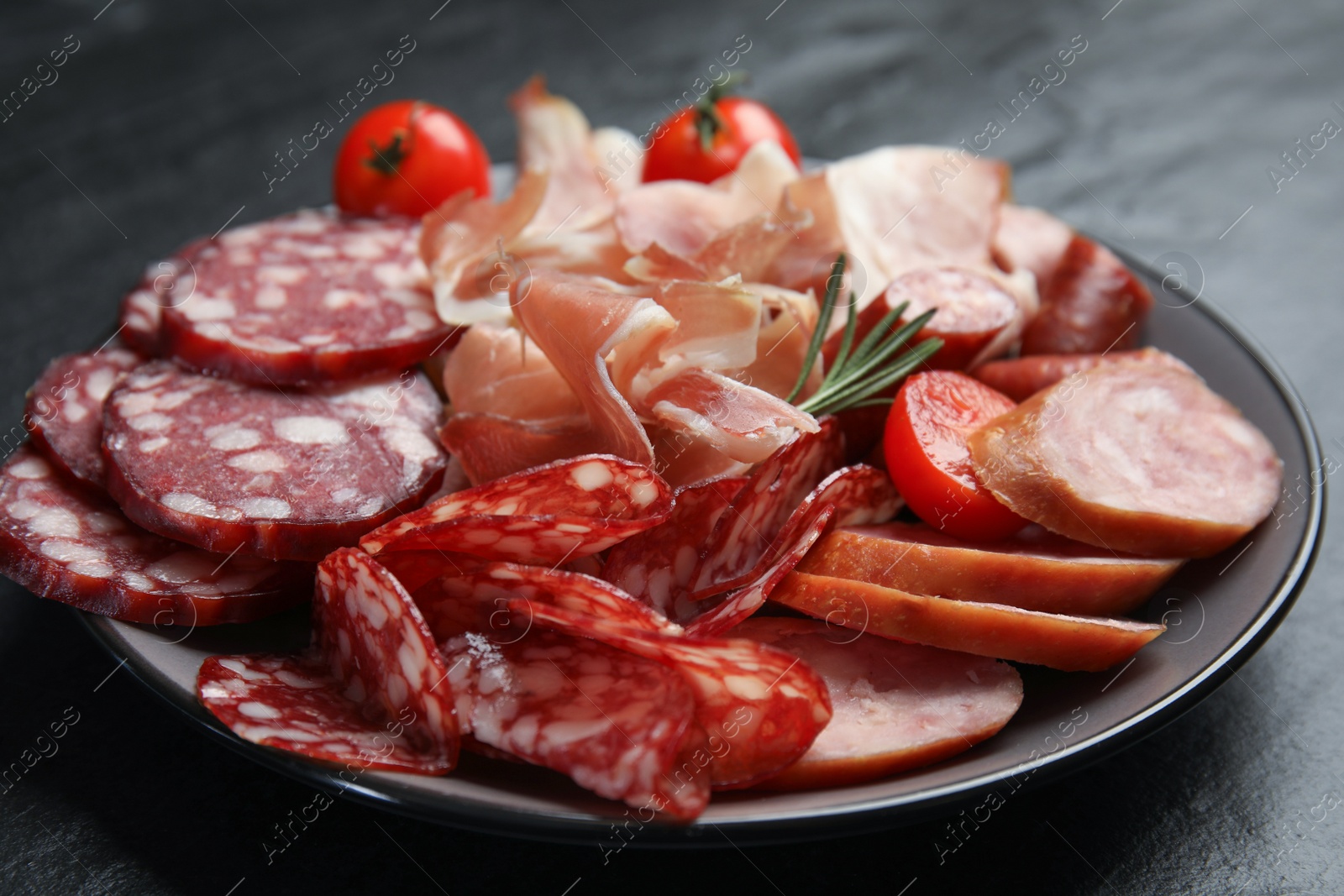 Photo of Different types of sausages served on black table, closeup