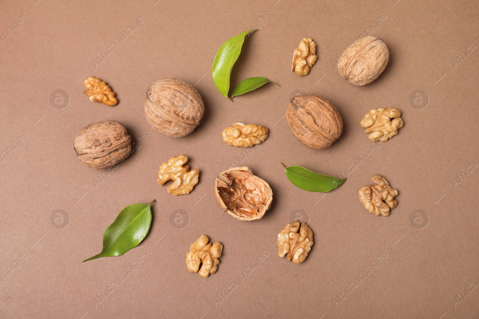 Photo of Flat lay composition with walnuts and leaves on color background, flat lay