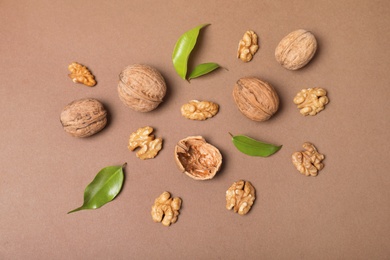 Photo of Flat lay composition with walnuts and leaves on color background, flat lay