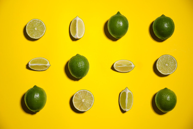 Flat lay composition with fresh juicy limes on yellow background