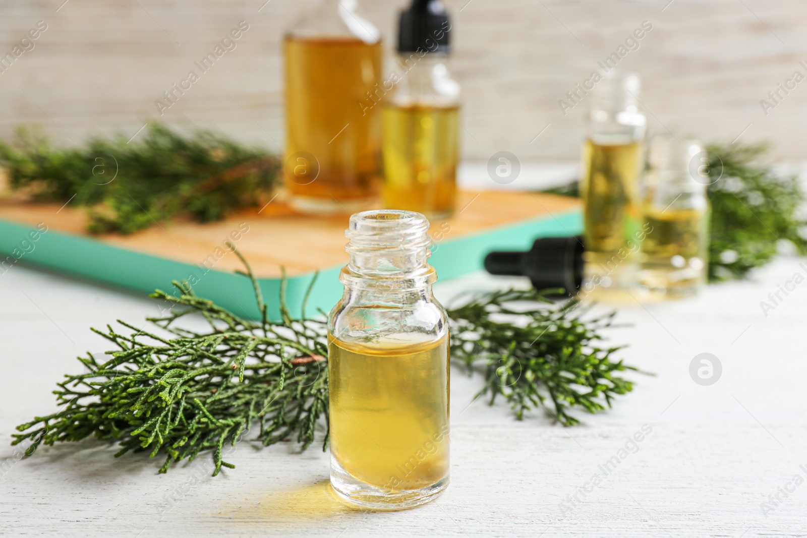 Photo of Composition with bottle of conifer essential oil on white wooden table