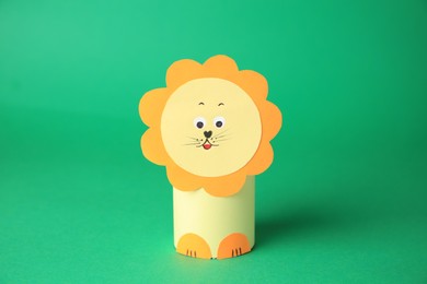 Photo of Toy lion made from toilet paper hub on green background. Children's handmade ideas