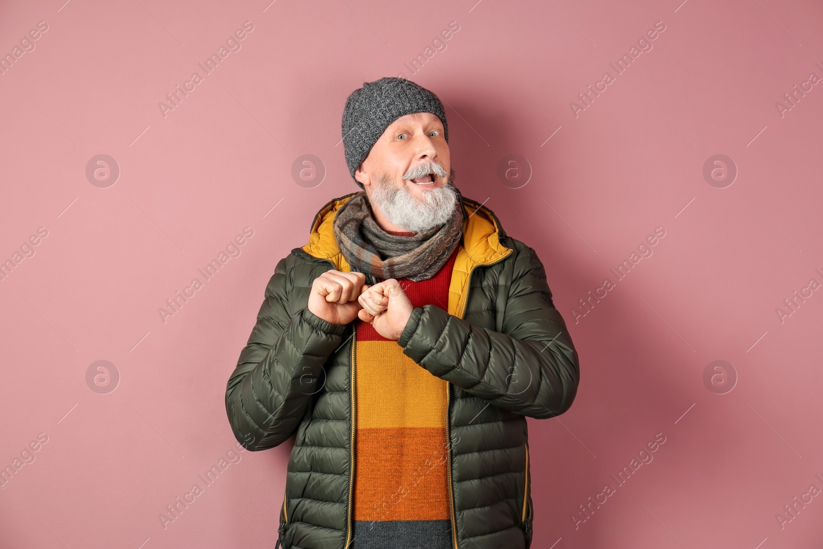 Photo of Mature man in warm clothing on color background. Ready for winter vacation