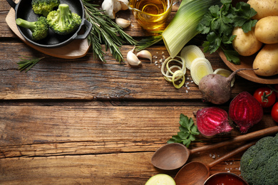 Flat lay composition with fresh products on wooden table, space for text. Healthy cooking