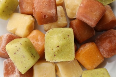 Different frozen fruit puree cubes on table, flat lay