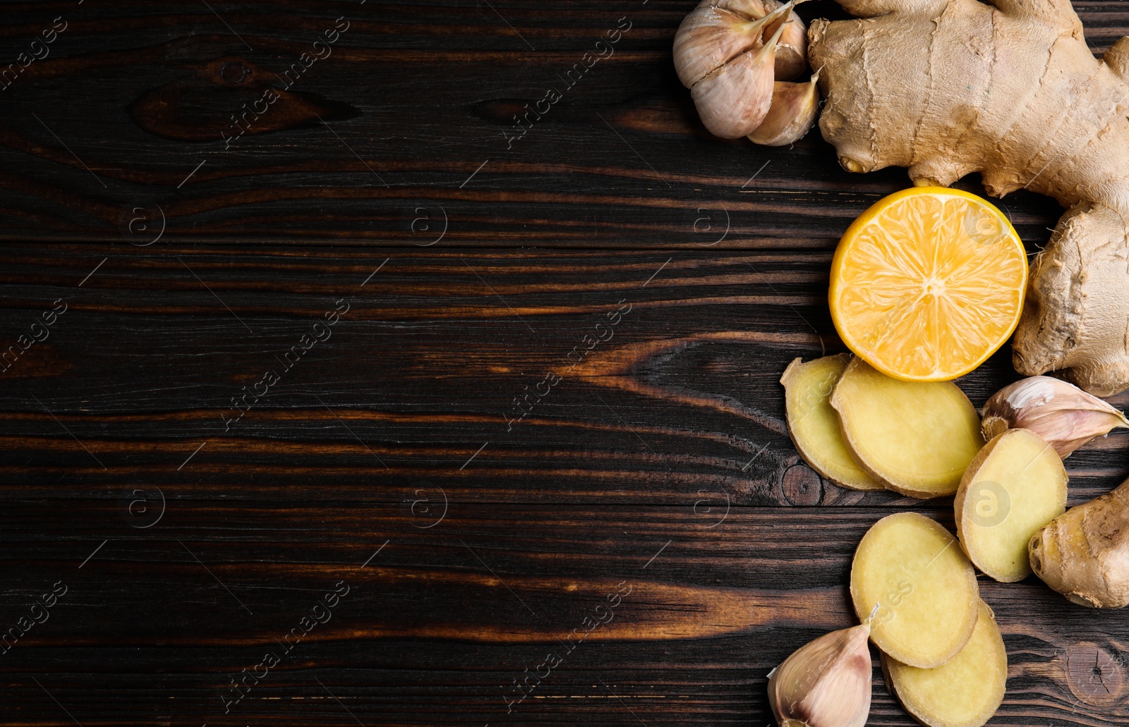 Photo of Fresh garlic and other natural cold remedies on wooden table, flat lay. Space for text