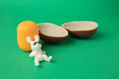 Photo of Slynchev Bryag, Bulgaria - May 25, 2023: Halves of Kinder Surprise Egg, plastic capsule and toy bunny on green background