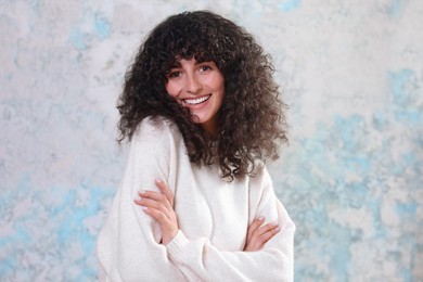Photo of Portrait of happy young woman in stylish sweater on color background