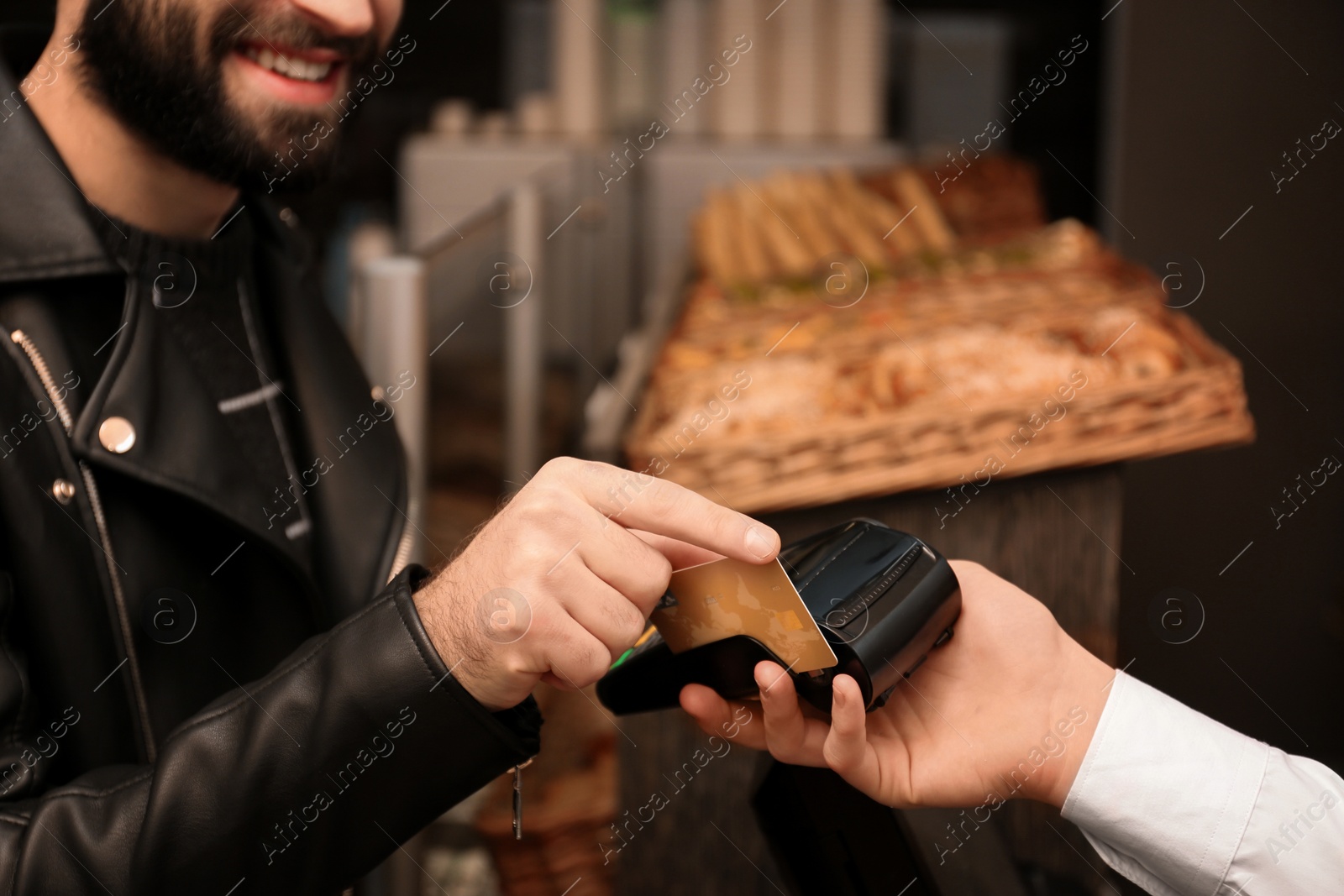 Photo of Man with credit card using payment terminal at shop, closeup