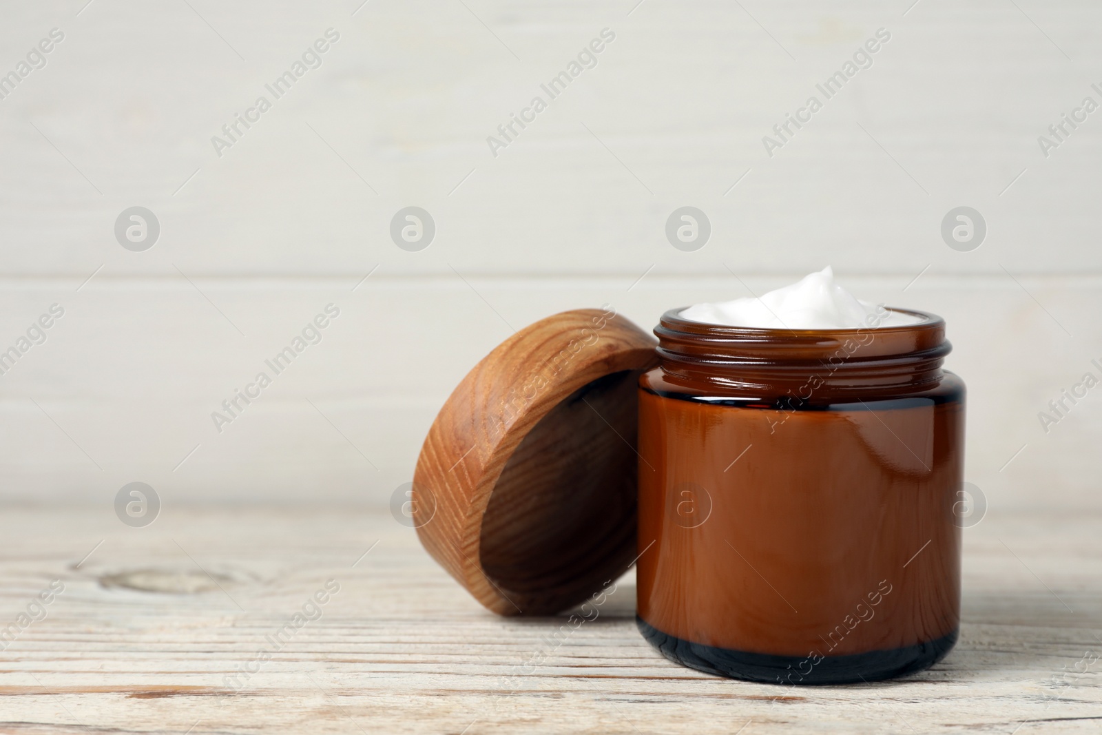 Photo of Jar of face cream on white wooden table. Space for text