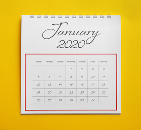 Photo of January 2020 calendar on yellow background, top view
