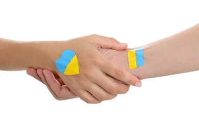 Photo of Man and woman with painted Ukrainian flags on their hands against white background, closeup