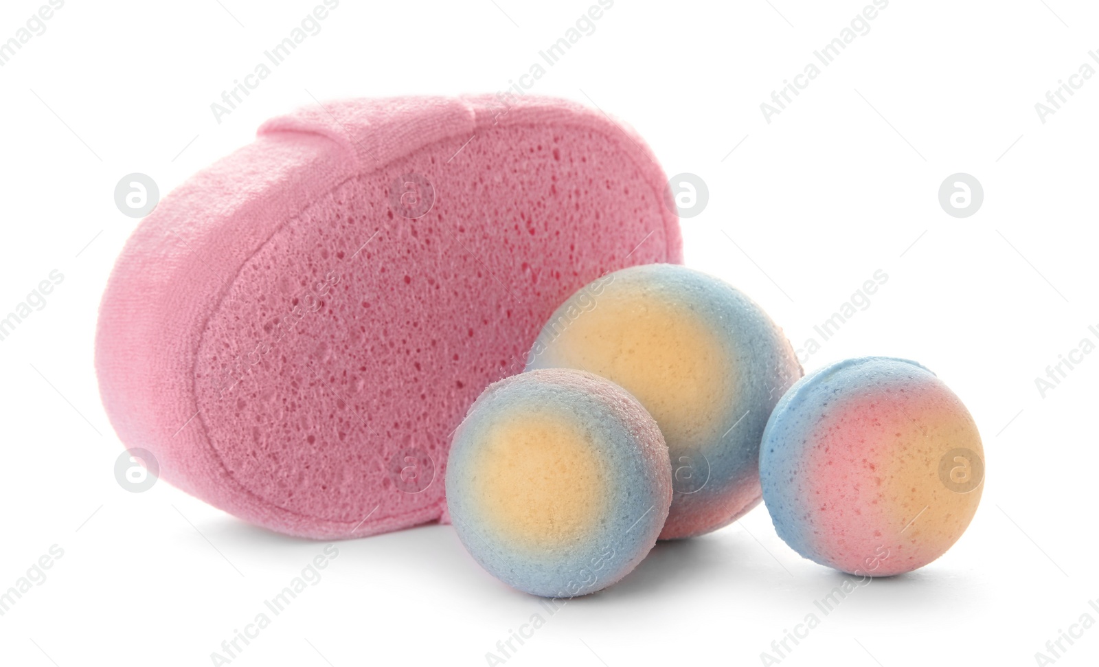 Photo of Pink sponge and bath bombs on white background