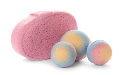 Photo of Pink sponge and bath bombs on white background