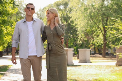 Happy couple walking along park on summer day