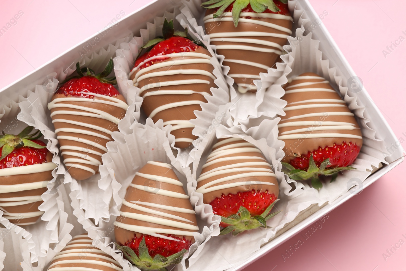 Photo of Box with delicious chocolate covered strawberries on pink background, top view