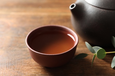 Cup of freshly brewed oolong tea on wooden table