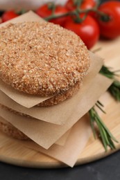 Photo of Raw vegan cutlets with breadcrumbs on black table, closeup