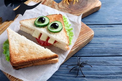 Cute monster sandwich served on blue wooden table, closeup. Halloween party food