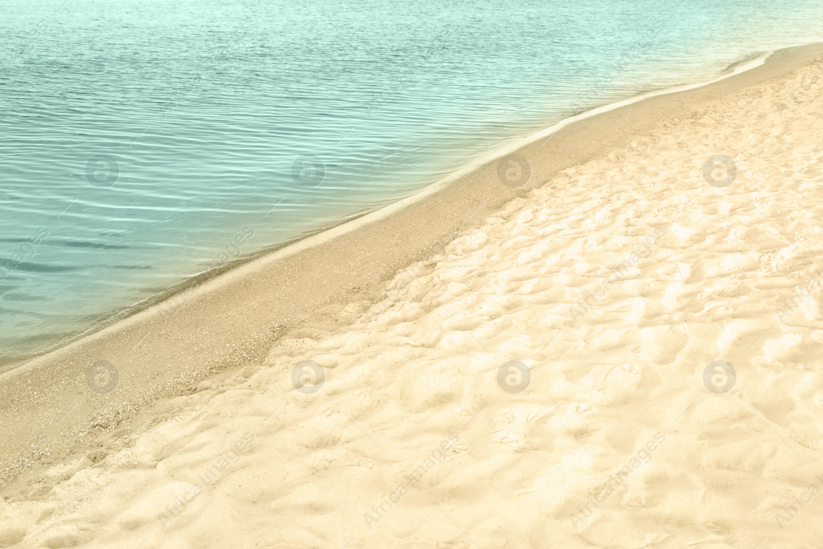 Photo of View of sea water and beach sand on sunny summer day