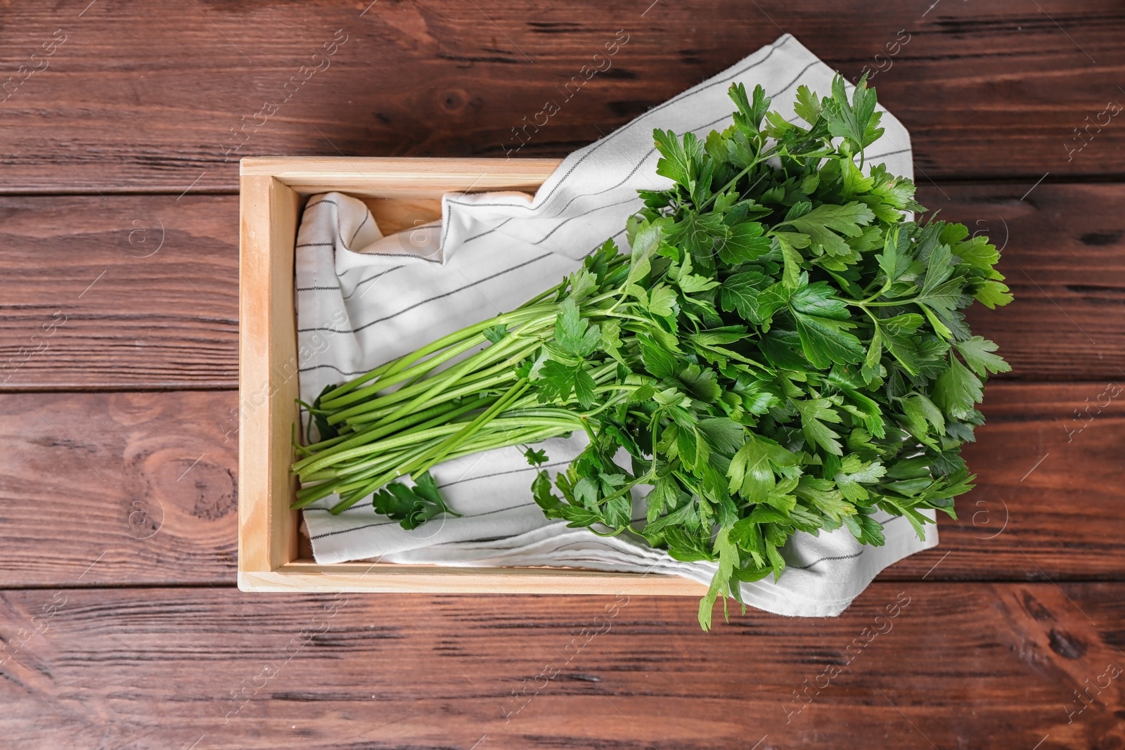 Photo of Crate with fresh green parsley on wooden background, top view