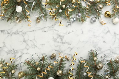 Serpentine streamers and Christmas decor on white marble background, flat lay. Space for text