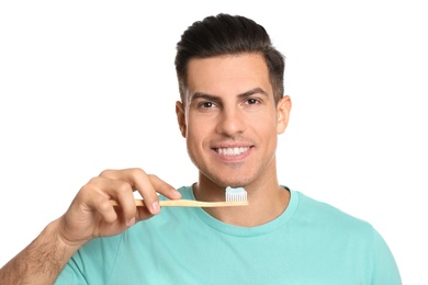 Photo of Man holding toothbrush with paste on white background