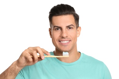 Man holding toothbrush with paste on white background