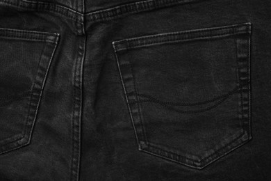 Black jeans with pocket as background, top view