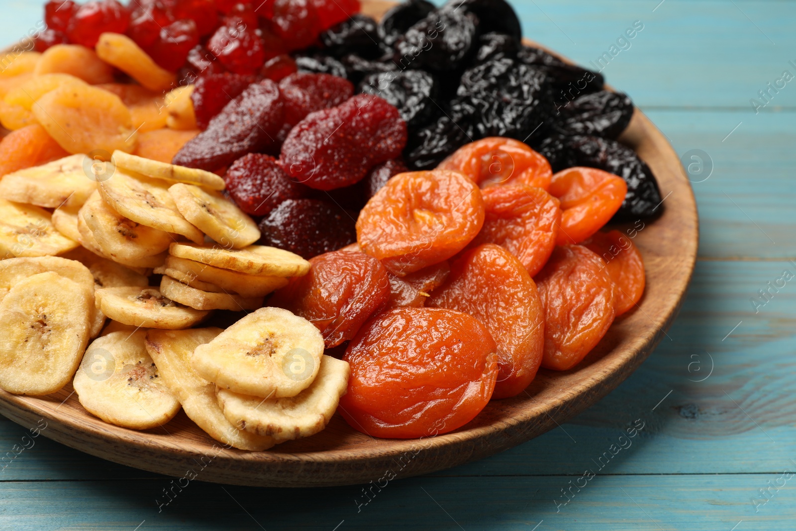 Photo of Delicious dried fruits on light blue wooden table, closeup