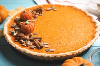 Photo of Delicious homemade pumpkin pie on light blue wooden table, closeup