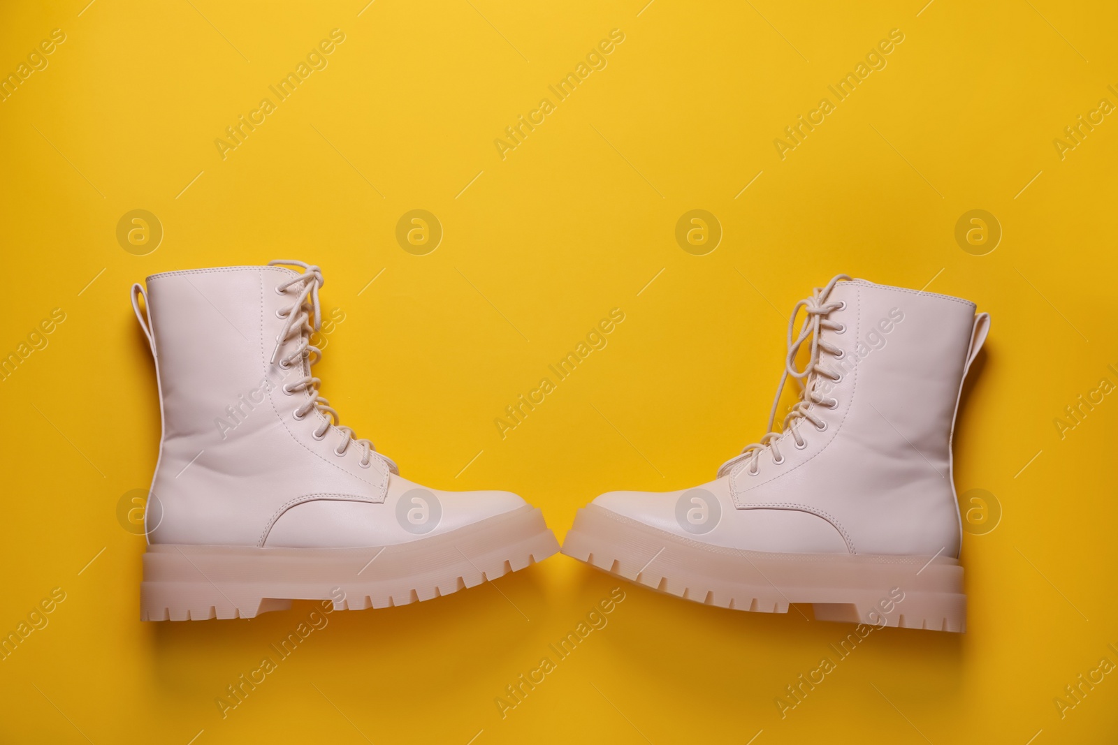 Photo of Pair of stylish shoes on yellow background, flat lay