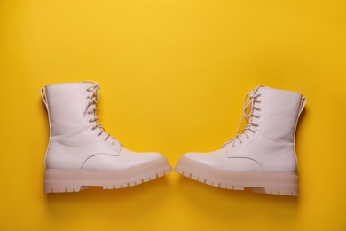 Photo of Pair of stylish shoes on yellow background, flat lay