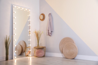 Photo of Large mirror with lamps in stylish room interior