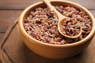 Delicious brown rice in bowl on wooden table