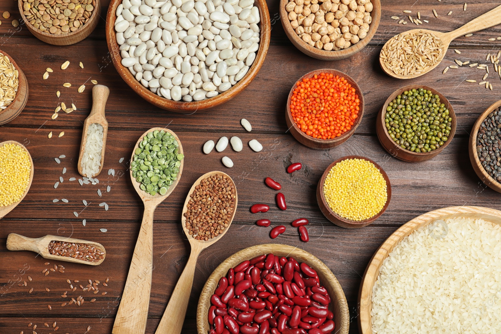 Photo of Flat lay composition with different types of legumes and cereals on wooden table. Organic grains
