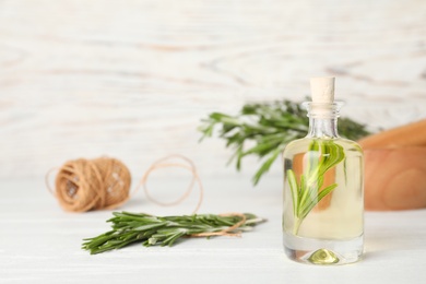 Composition with essential oil in glass bottle on table. Space for text