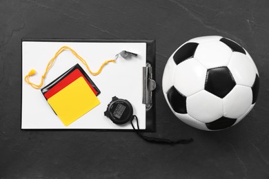 Photo of Soccer ball and different referee equipment on black table, top view