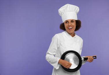 Photo of Happy female chef with frying pan having fun on purple background. Space for text