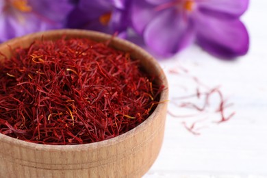 Photo of Dried saffron and crocus flowers on white table, closeup. Space for text