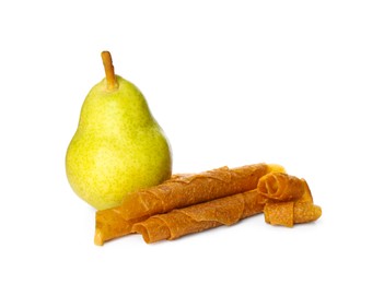 Delicious fruit leather rolls and pear on white background