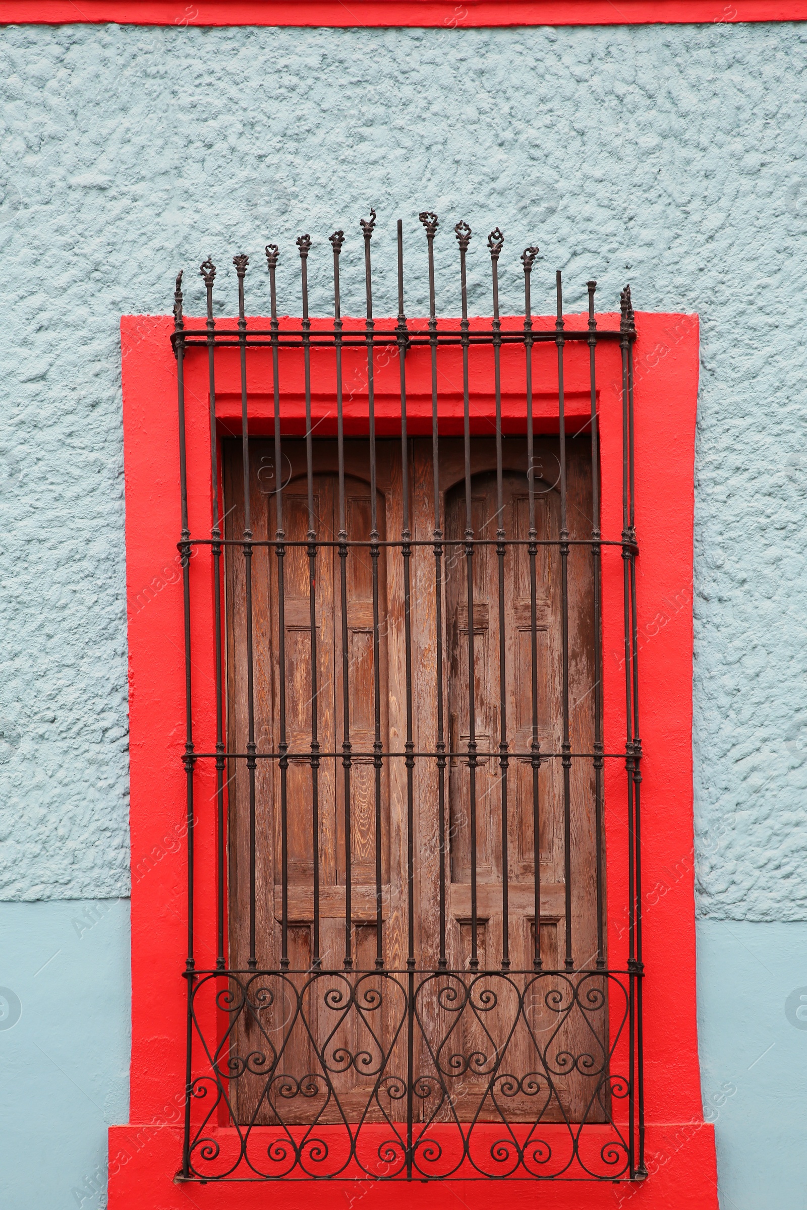 Photo of Light blue building with beautiful window and steel grilles