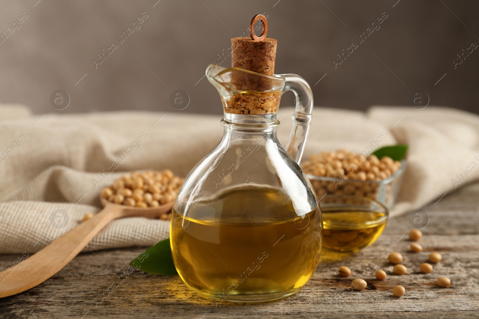 Photo of Composition with soybean oil on wooden table