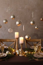 Christmas table setting with burning candles and festive decor