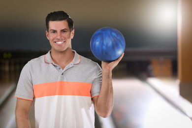 Photo of Man with ball in modern bowling club