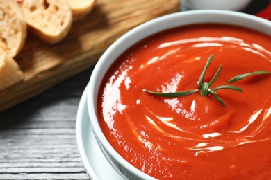 Photo of Bowl with fresh homemade tomato soup on table, closeup. Space for text