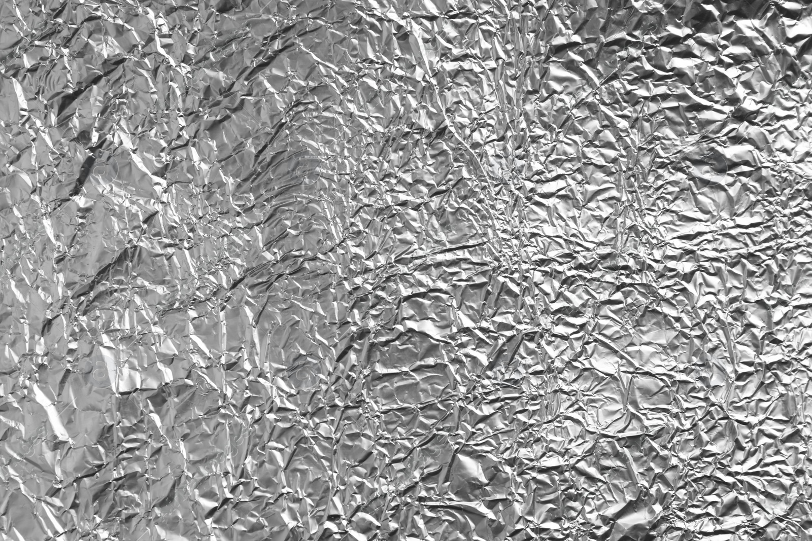 Photo of Crumpled silver foil as background, closeup view