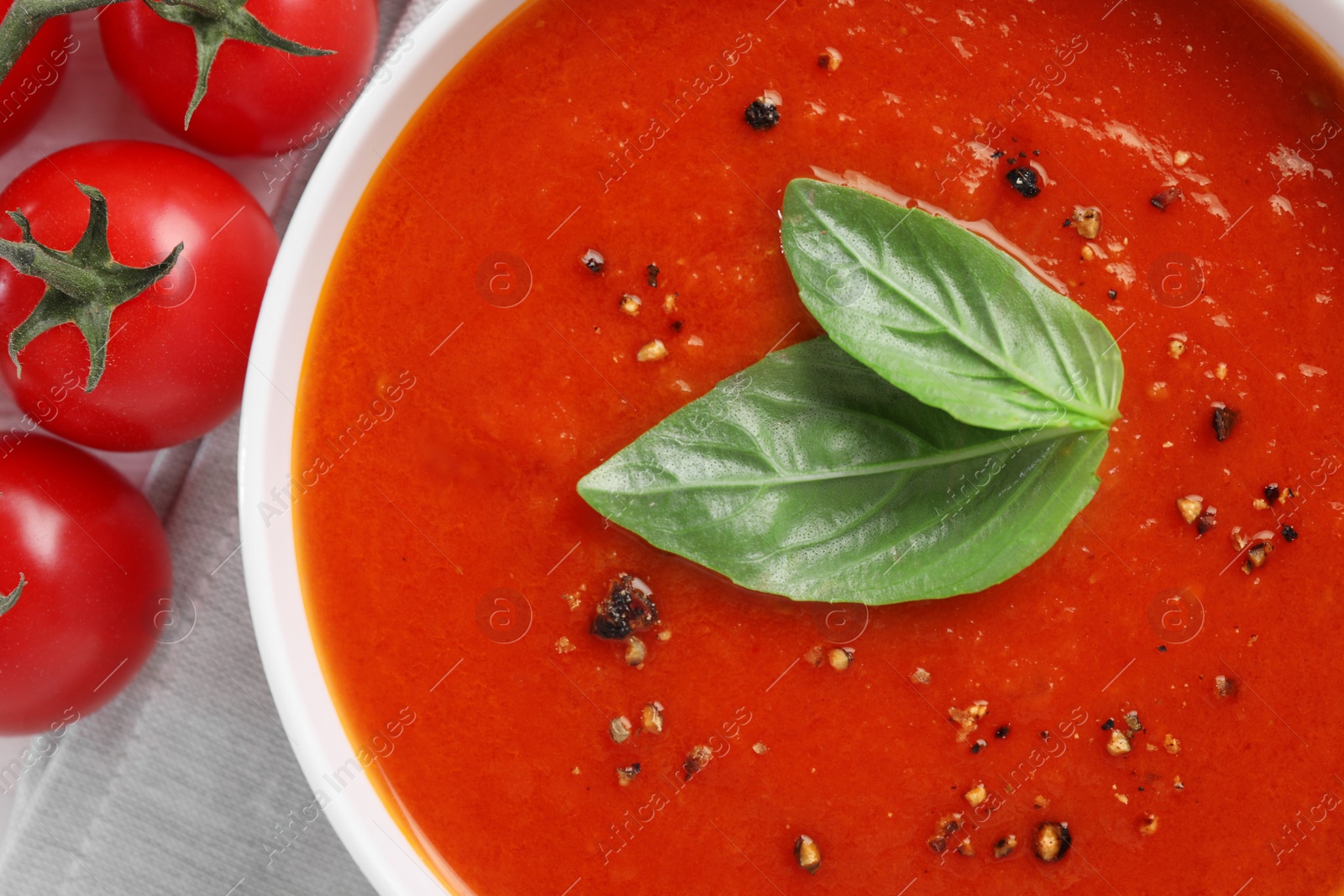 Photo of Delicious tomato cream soup in bowl on table, top view