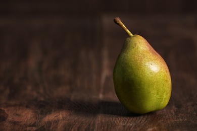 Photo of Ripe pear on wooden background. Space for text