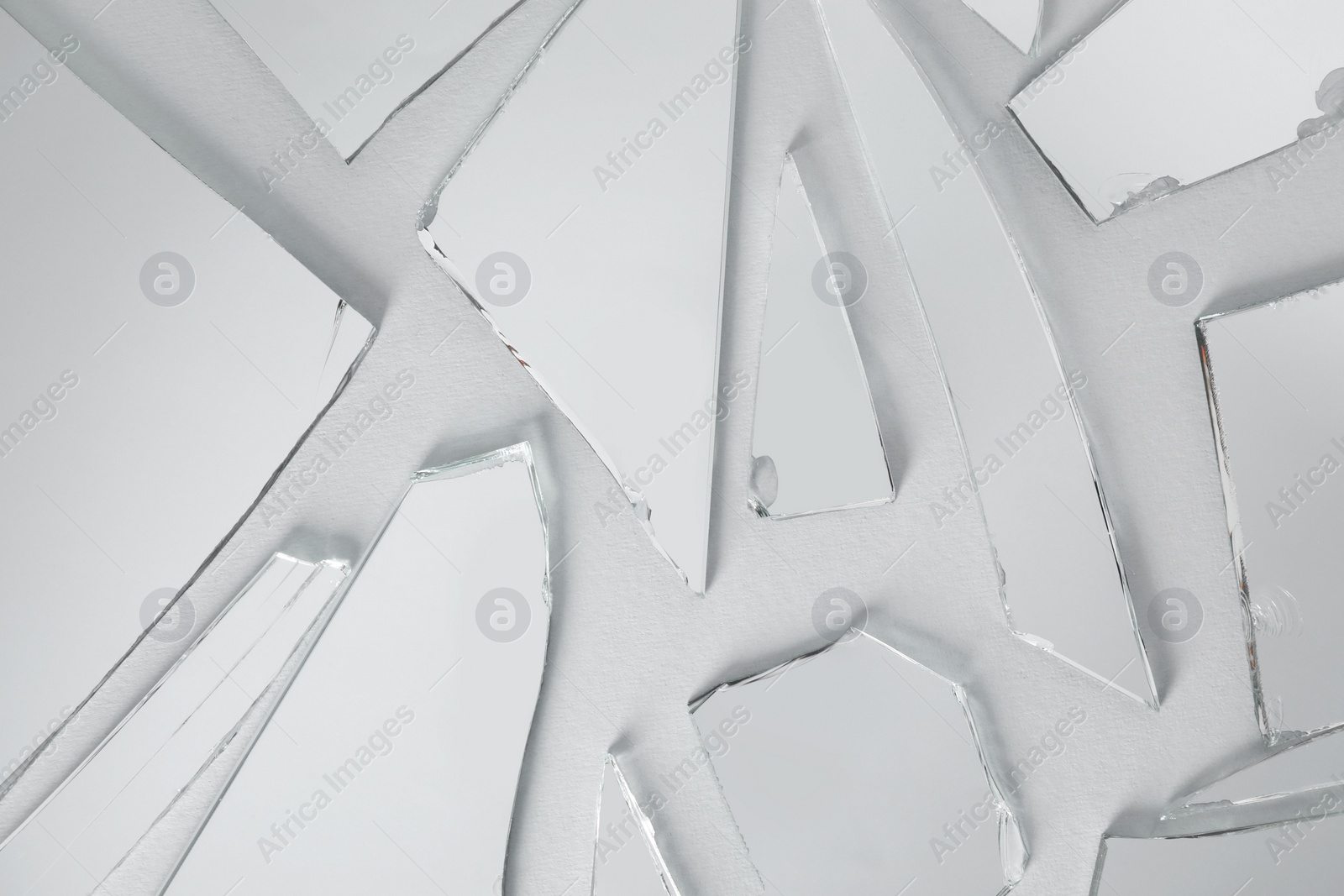 Photo of Shards of broken mirror on white background, top view